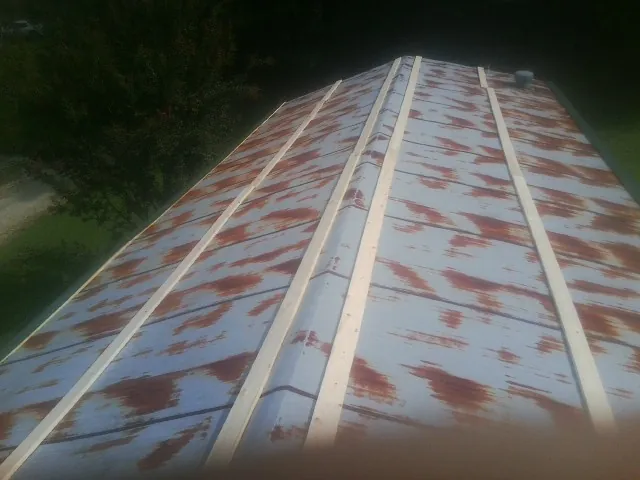 Rusted metal roof panels with new wood purlins before replacement — Storm Damage Roof Repair in Russellville by Roofing Brothers